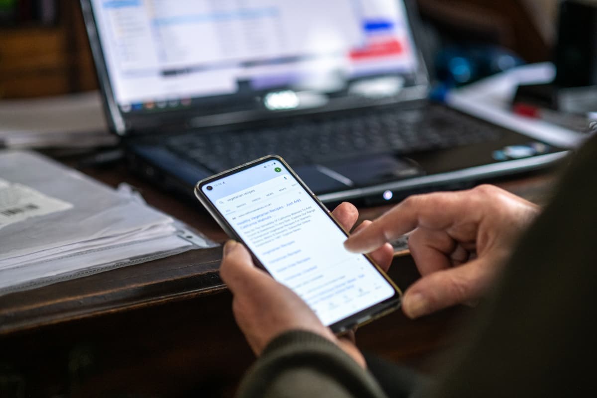 Hands holding a phone showing a suspicious text message